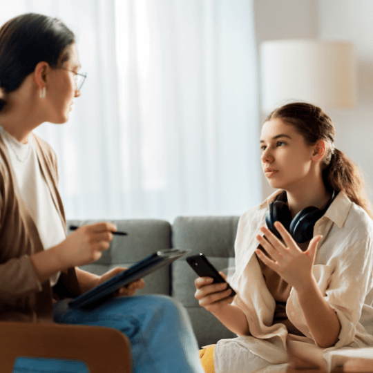 women and young person with mobile device speaking
